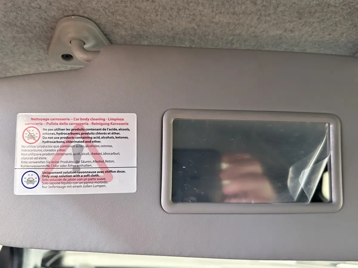 Image ne montrant pas le véhicule AIXAM AMBITION 0.5 CITY GTO, mais un miroir de pare-soleil intérieur avec consignes de nettoyage.