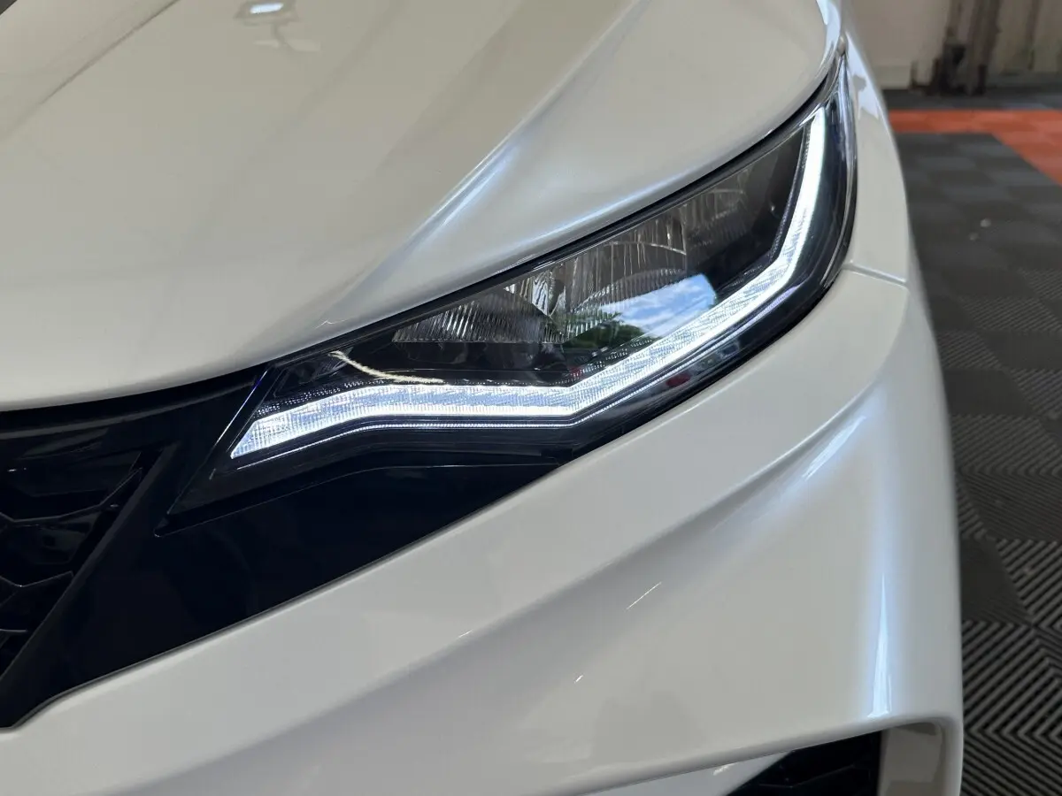 Gros plan sur le phare avant droit blanc de l'AIXAM AMBITION 0.5 CITY GTO 2026 avec éclairage LED distinctif.