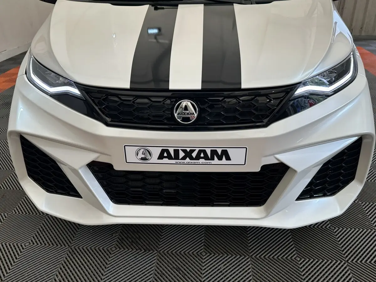 Vue avant rapprochée de l'AIXAM AMBITION 0.5 CITY GTO blanche avec bandes noires sur le capot et calandre noire.