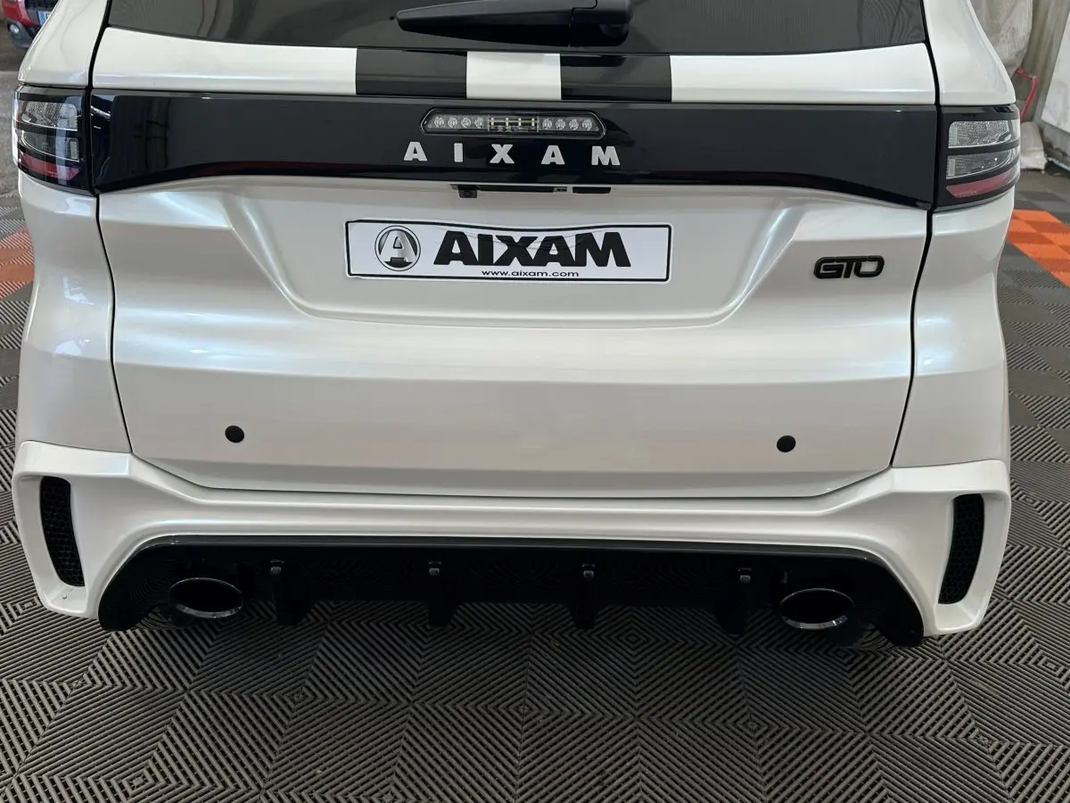 Vue arrière d'une Aixam Ambition 0.5 City GTO blanche avec logo AIXAM et badge GTO sur fond noir.
