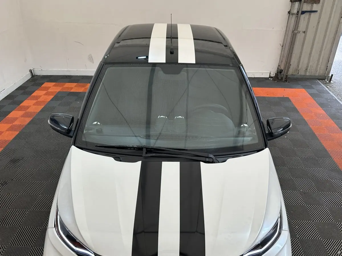 Vue plongeante avant d'une Aixam Ambition 0.5 City GTO blanche avec bandes noires sur le capot et le toit.