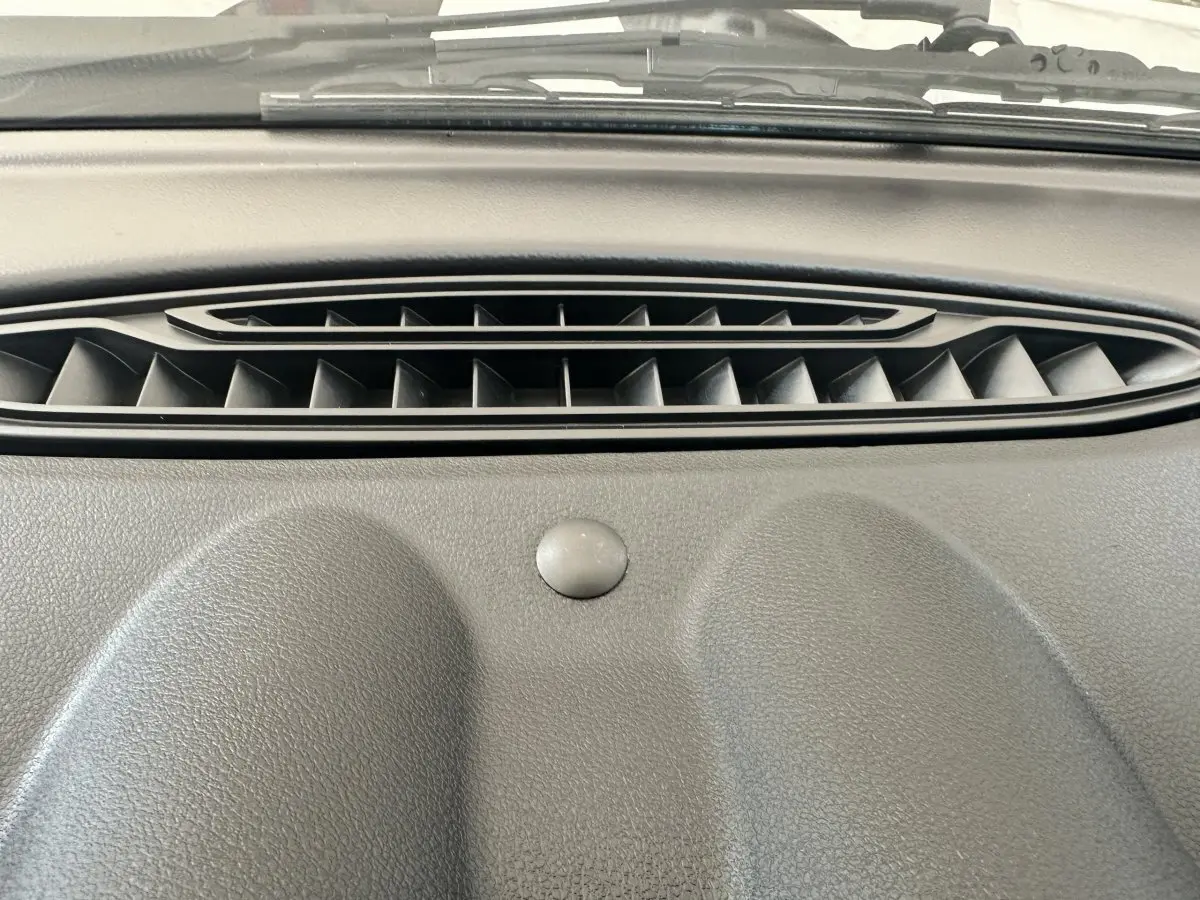 Gros plan sur la sortie d'air centrale du tableau de bord gris de l'AIXAM AMBITION 0.5 CITY GTO 2026.