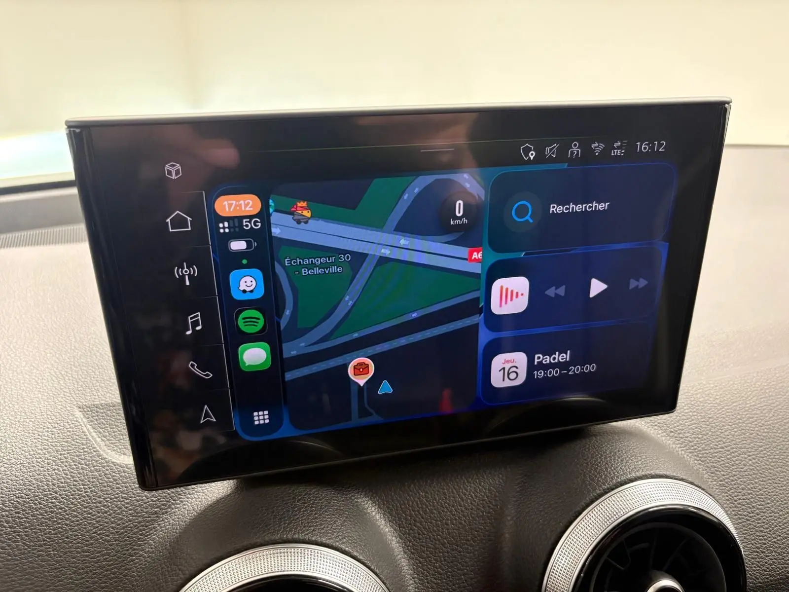 Écran tactile central de l'Audi Q2 35 TFSI 2026 affichant la navigation et les applications, intérieur noir.