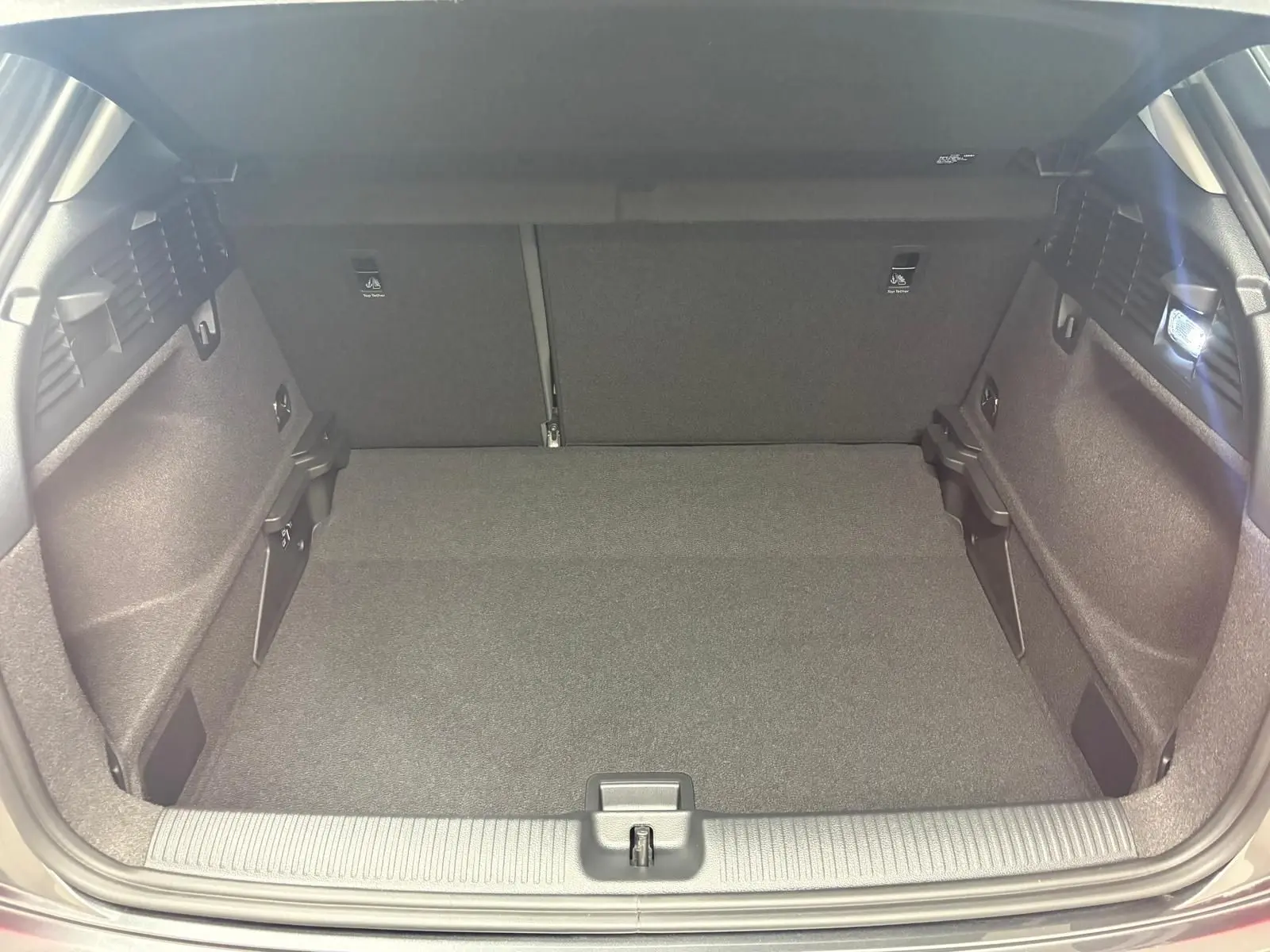 Coffre ouvert vu de l'arrière d'un Audi Q2 35 TFSI S Line 2026 en gris Daytona, espace de chargement vide et propre.