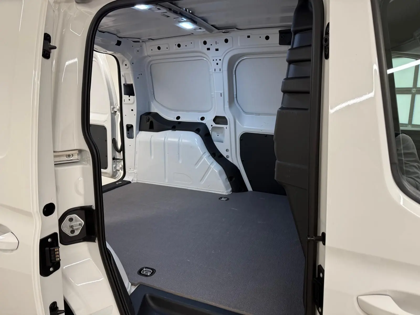 Vue intérieure côté droit du compartiment de charge blanc candy du Volkswagen Caddy 2.0 TDI 122 DSG7 Business 2025.