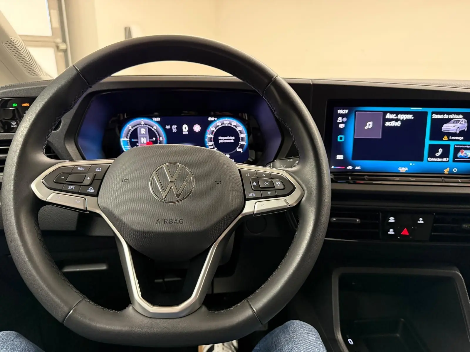 Vue intérieure centrée sur le volant cuir noir et le tableau de bord digital du Volkswagen Caddy 2025.