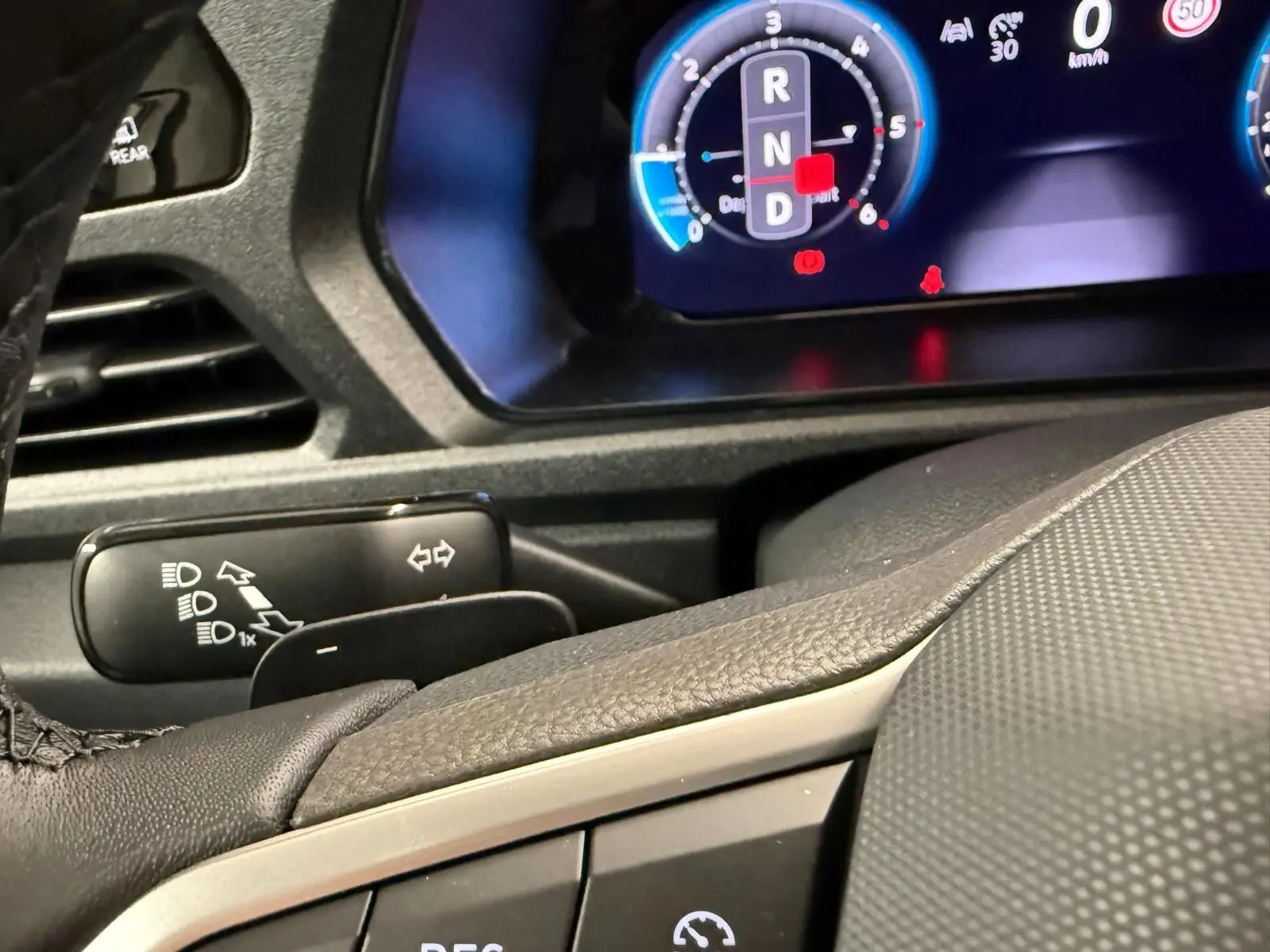 Gros plan sur le tableau de bord digital et le volant cuir du Volkswagen Caddy 2.0 TDI 122 DSG7 Business.