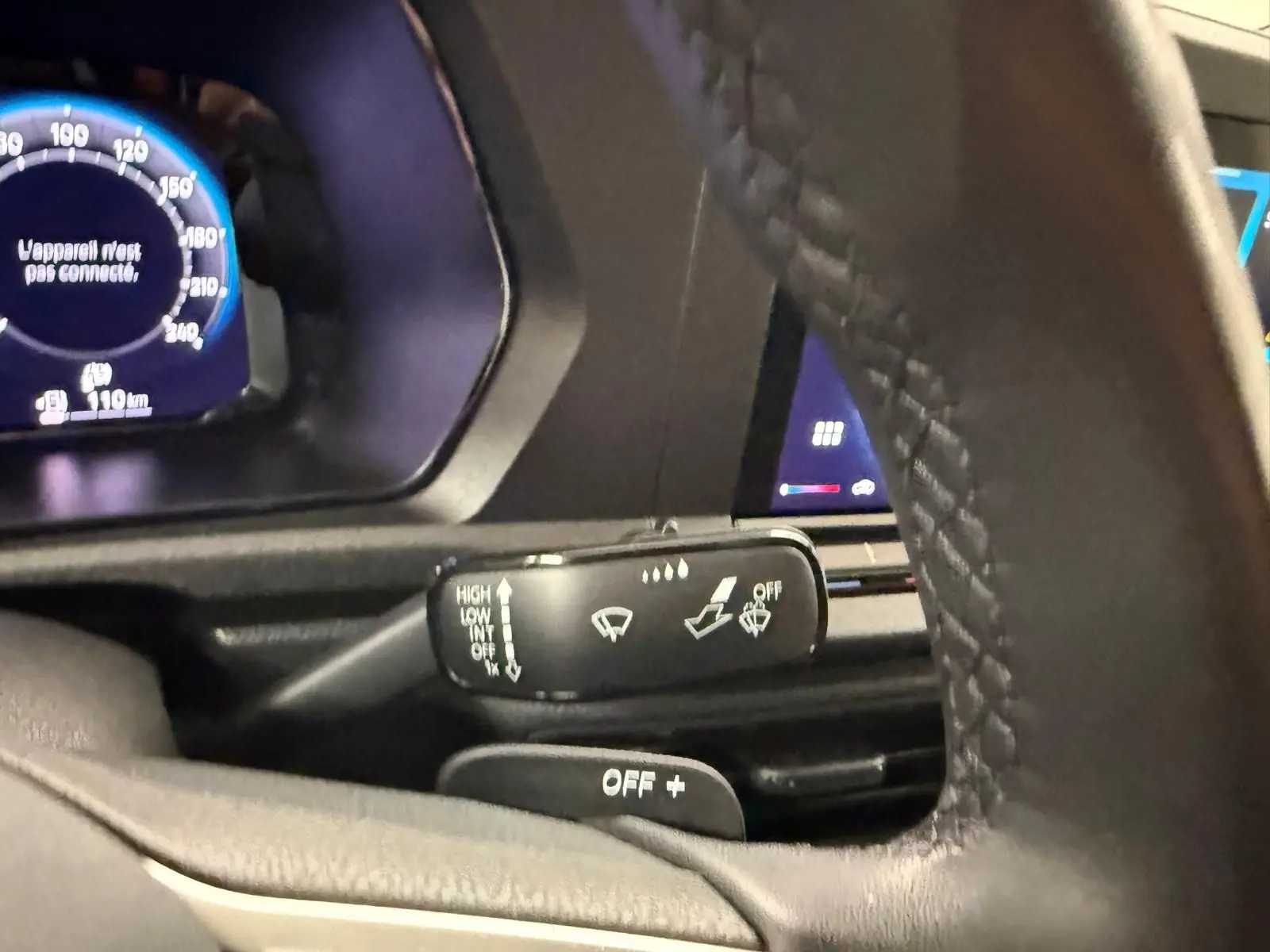 Gros plan sur la commande d’essuie-glace côté gauche du volant cuir du Volkswagen Caddy blanc 2025.