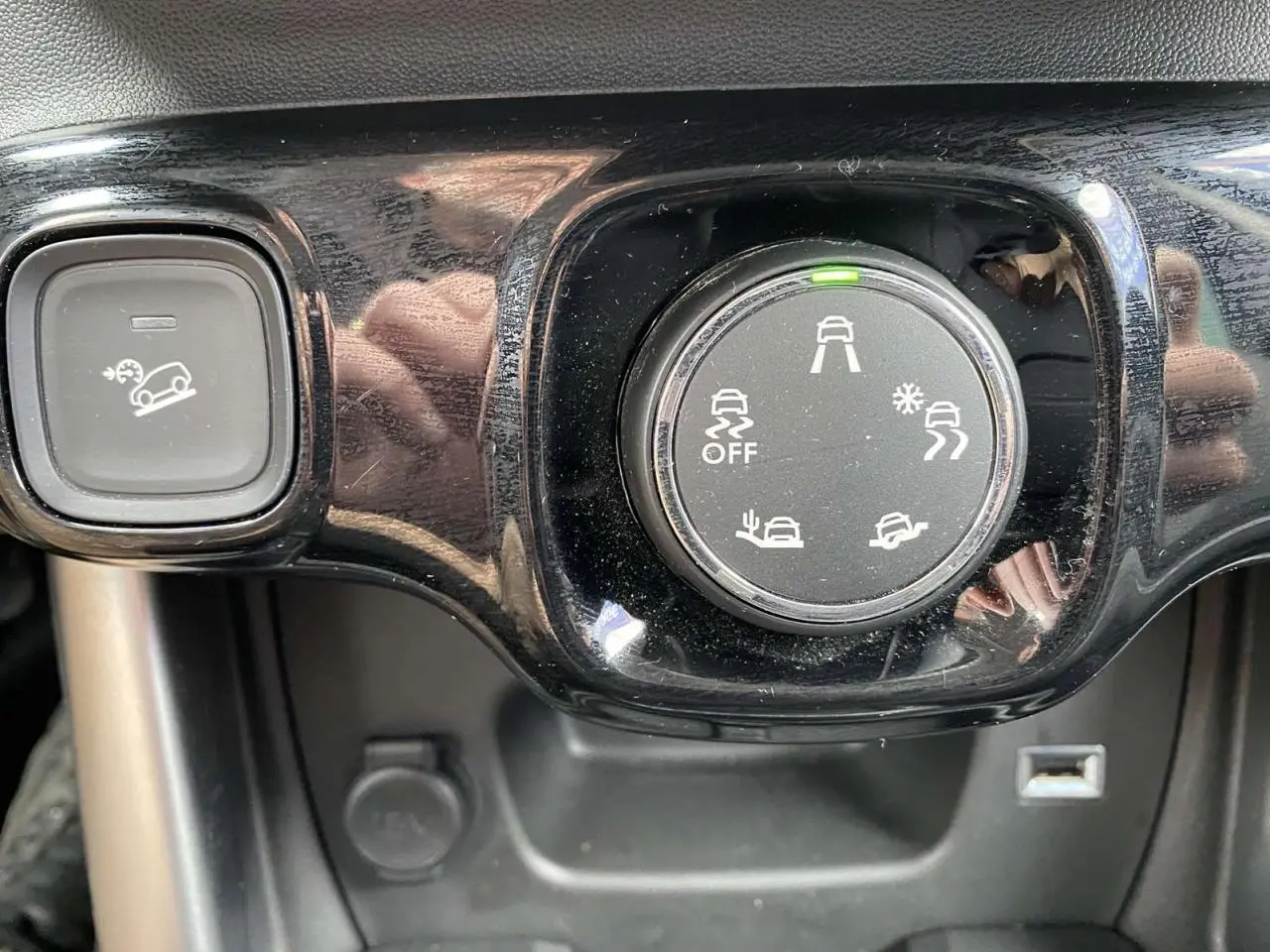 Gros plan sur le sélecteur de modes de conduite et le bouton d’aide à la descente dans l’habitacle du Citroën C3 Aircross gris.