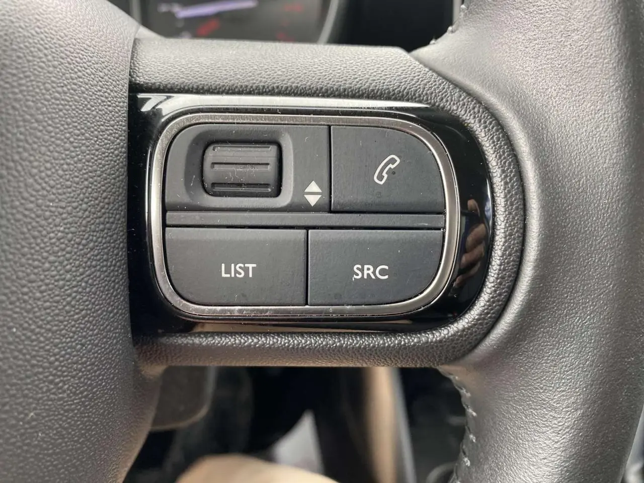 Détail des commandes noires sur le volant du Citroën C3 Aircross 2020, version grise essence, vue rapprochée.