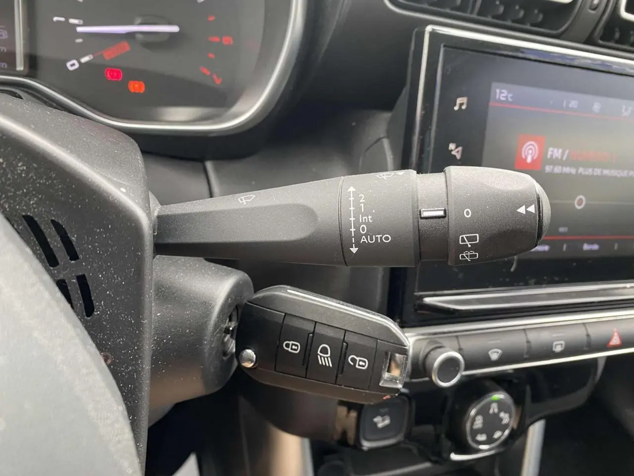 Gros plan sur la commande d'essuie-glace et la clé de contact dans l'habitacle gris du Citroën C3 Aircross 2020.