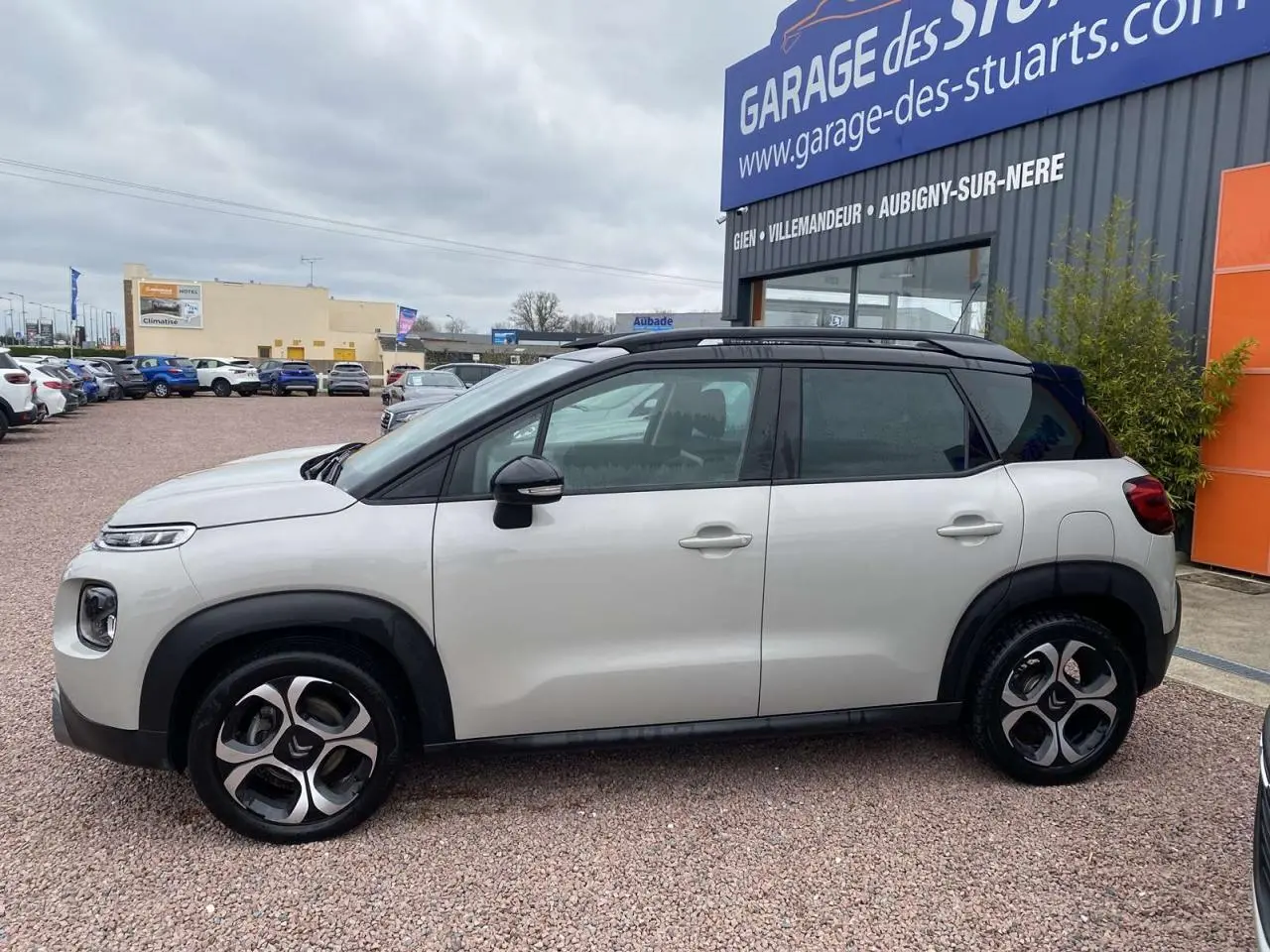 Vue de profil côté gauche d'une Citroën C3 Aircross grise 2020 avec toit noir et jantes distinctives bicolores.