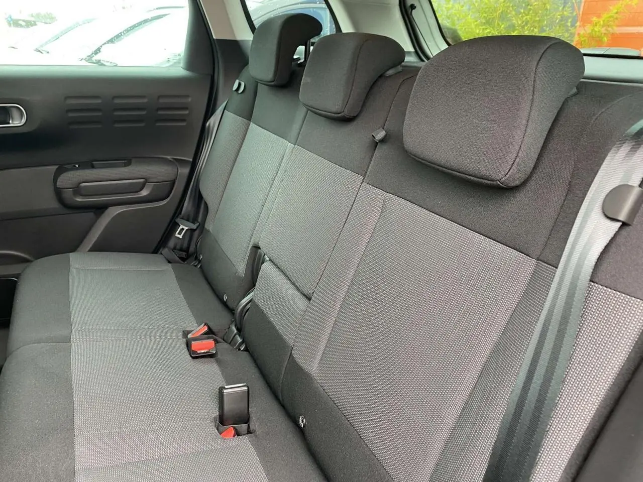 Vue intérieure de la banquette arrière grise du Citroën C3 Aircross 2020, avec appuie-têtes et ceintures visibles.