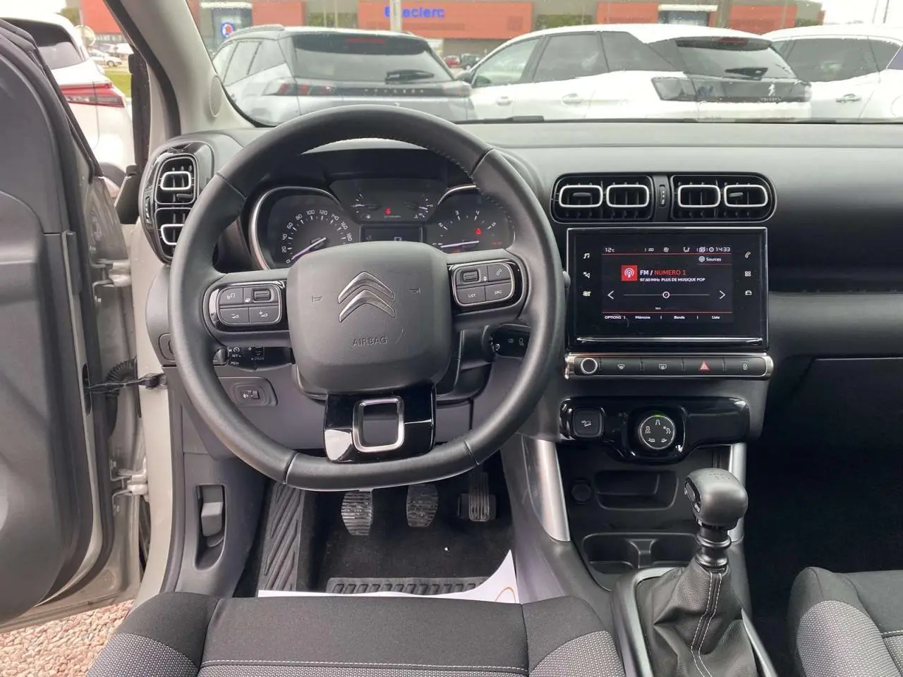 Vue intérieure frontale du tableau de bord gris du Citroën C3 Aircross 2020 avec volant multifonctions et boîte manuelle.