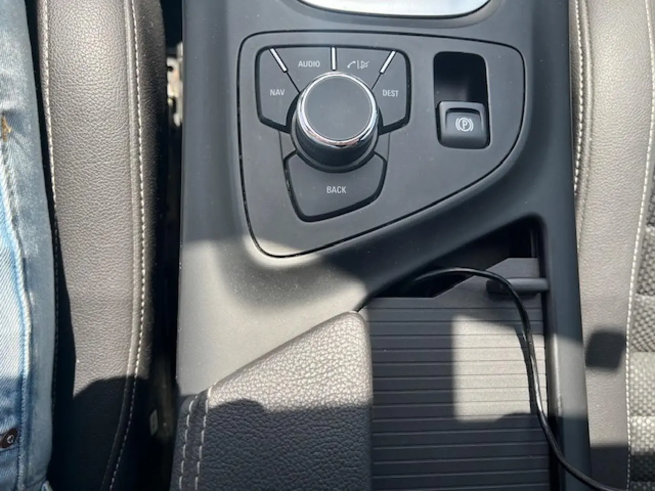 Vue rapprochée de la console centrale de l'Opel Insignia Sports Tourer 2011, avec commande multimédia et frein de parking électrique.