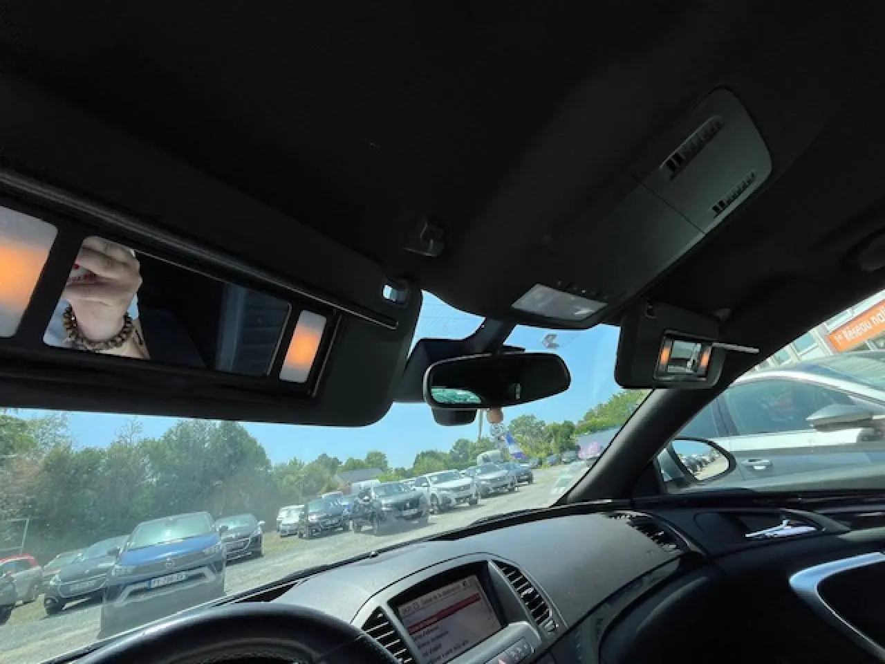 Vue intérieure avant droite de l’Opel Insignia Sports Tourer gris clair, avec tableau de bord et rétroviseur central visibles.