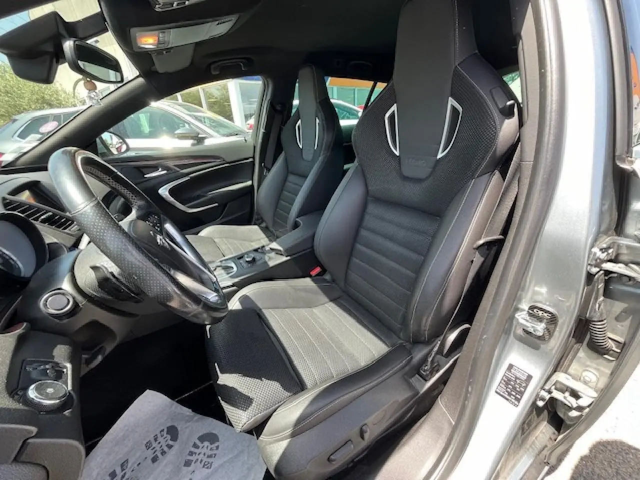 Vue intérieure côté conducteur de l’Opel Insignia Sports Tourer gris clair, sièges sport en cuir et alcantara avec finitions argentées.