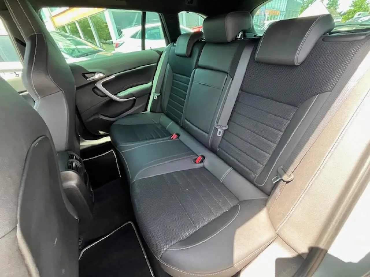 Vue intérieure arrière droite des sièges en cuir noir de l’Opel Insignia Sports Tourer gris clair de 2011.