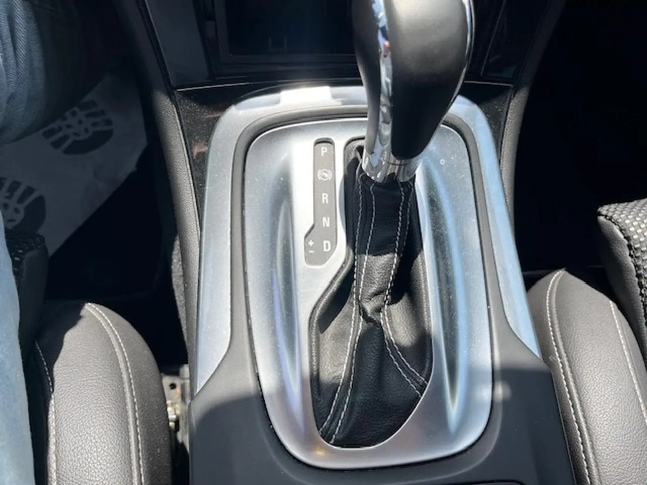 Le levier de vitesses automatique en cuir noir avec surpiqûres blanches dans l’habitacle d’une Opel Insignia Sports Tourer gris clair.