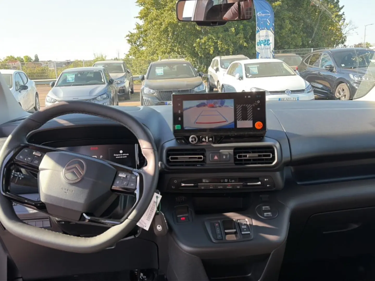 Vue intérieure du tableau de bord du Citroën Berlingo gris, avec écran tactile affichant la caméra de recul.