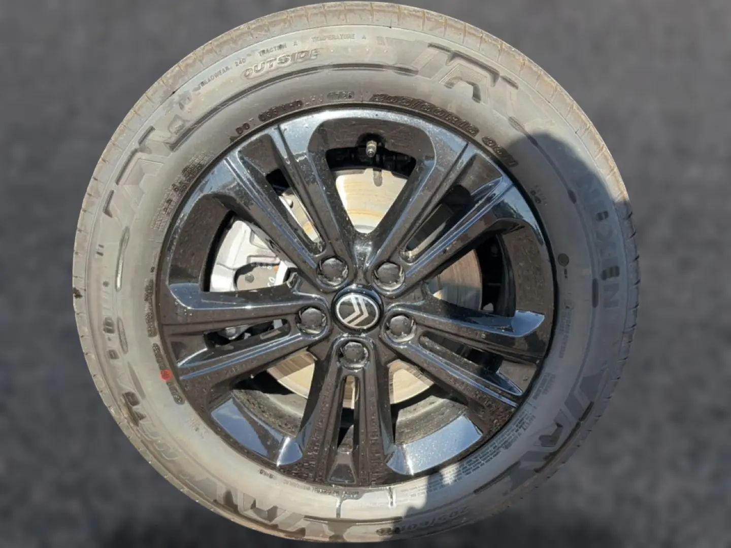 Gros plan sur la jante alu noire du Citroën Berlingo Steel Grey avec logo Citroën au centre.
