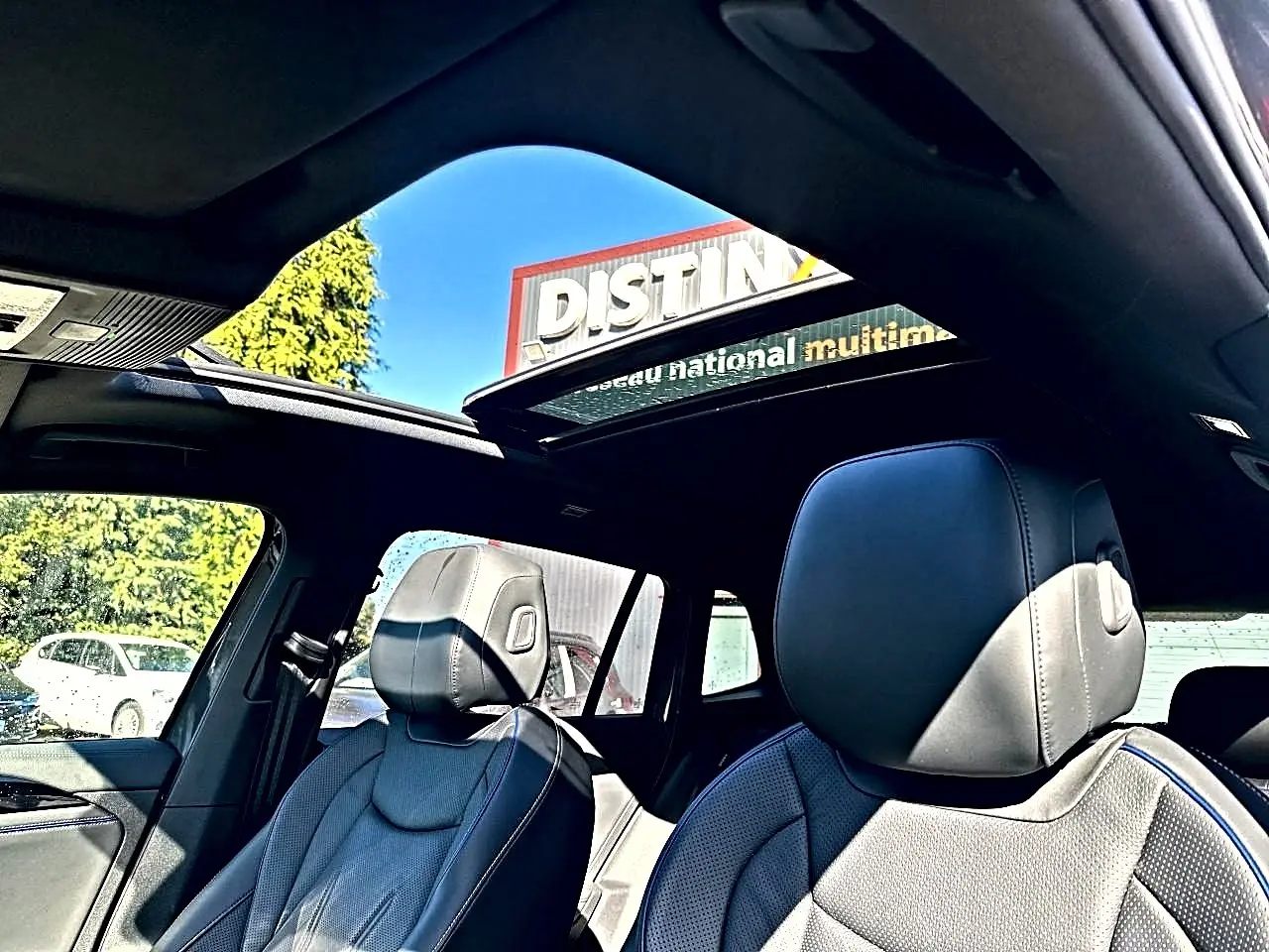 Vue intérieure du Volkswagen Tiguan gris dauphin 2024, sièges cuir noir R-Line et toit ouvrant panoramique en verre.