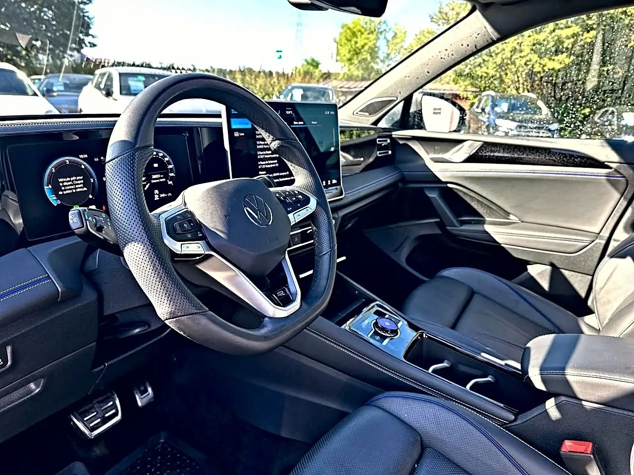 Vue intérieure côté conducteur du Volkswagen Tiguan 2024, volant cuir noir et tableau de bord digital.