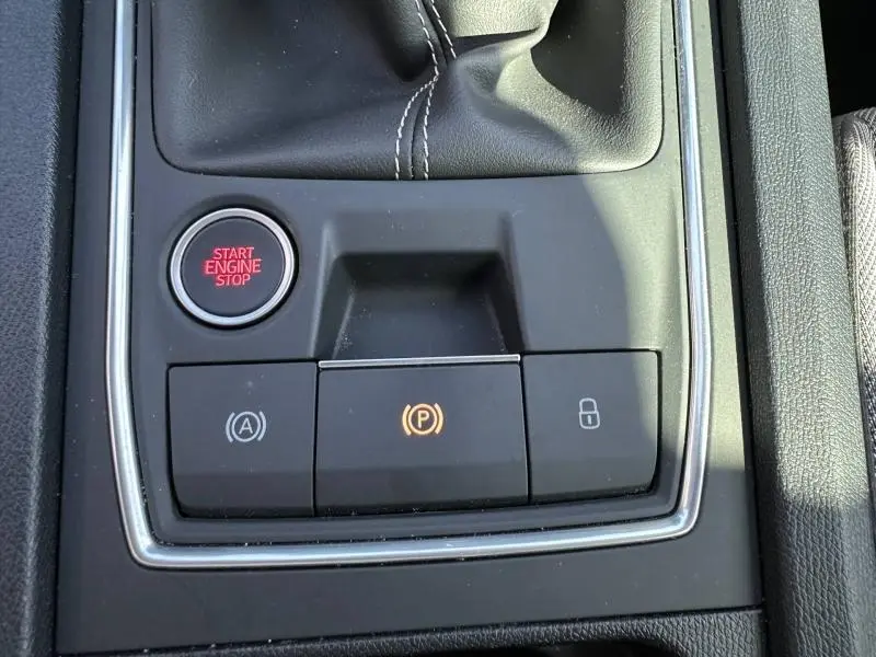 Vue rapprochée de la console centrale du SEAT LEON ST 2.0 TDI 115ch STYLE XL 2025 avec bouton Start/Stop et frein à main électronique.
