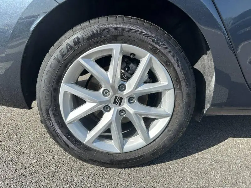 Gros plan sur la roue avant gauche d’un SEAT LEON ST gris magnétique métallisé avec jante alliage à 5 doubles branches.