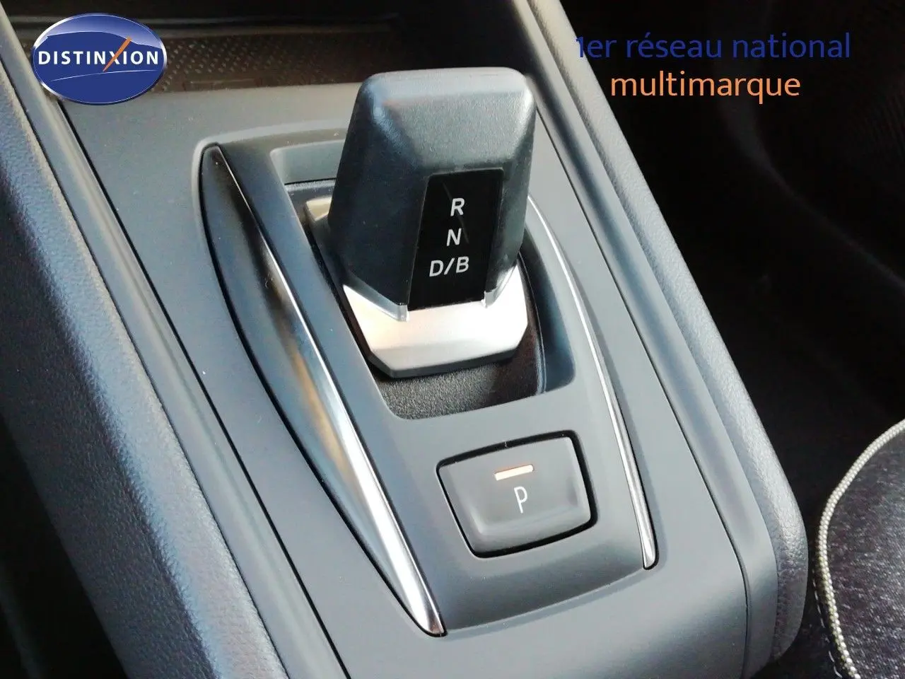 Gros plan sur la commande de boîte automatique noire du Renault Captur E-Tech 2026, avec bouton de parking éclairé.