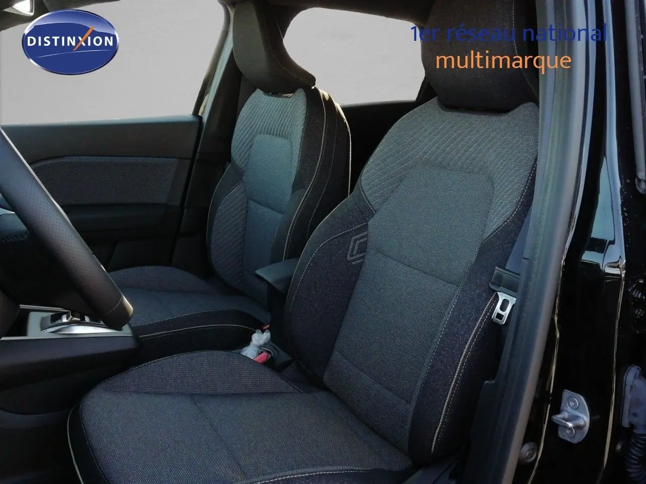 Vue intérieure côté conducteur du Renault Captur noir étoile métal, mettant en valeur les sièges en tissu gris foncé.