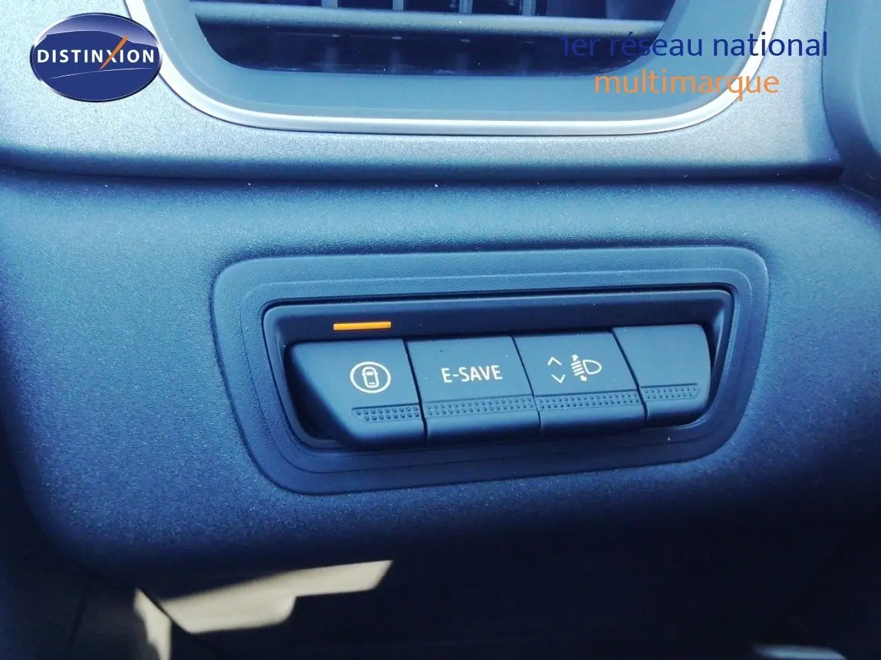 Gros plan sur les commandes E-SAVE et réglage des phares du tableau de bord du Renault Captur noir étoile métal 2026.