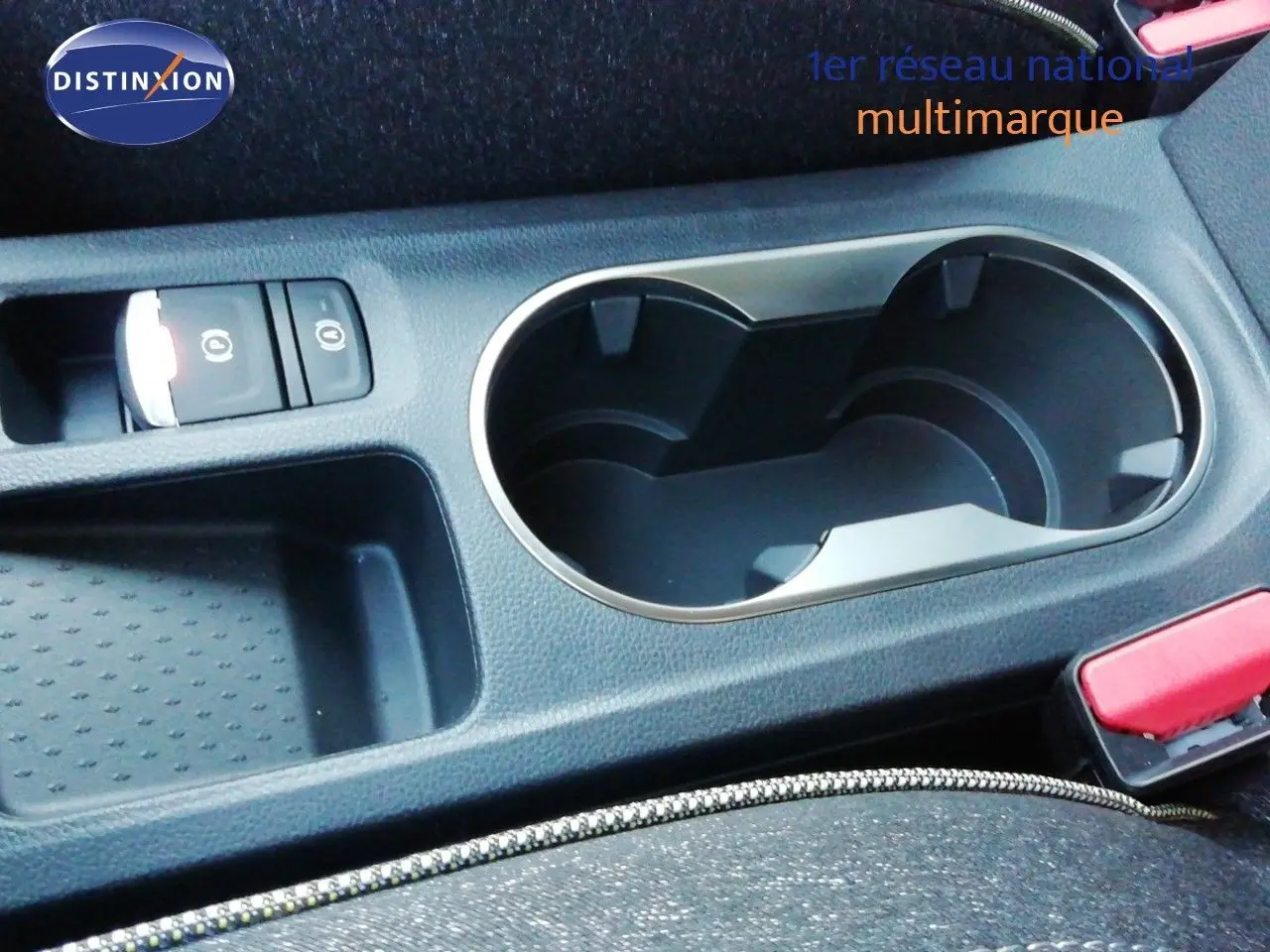 Gros plan sur la console centrale du Renault Captur 2026 noir étoile métal, avec porte-gobelets et bouton frein à main électrique.