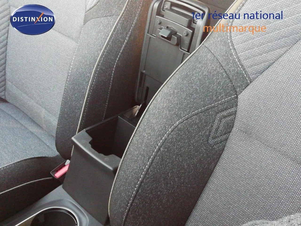Gros plan sur l’accoudoir central ouvert et les sièges en tissu gris du Renault Captur E-Tech Full Hybrid 2026.