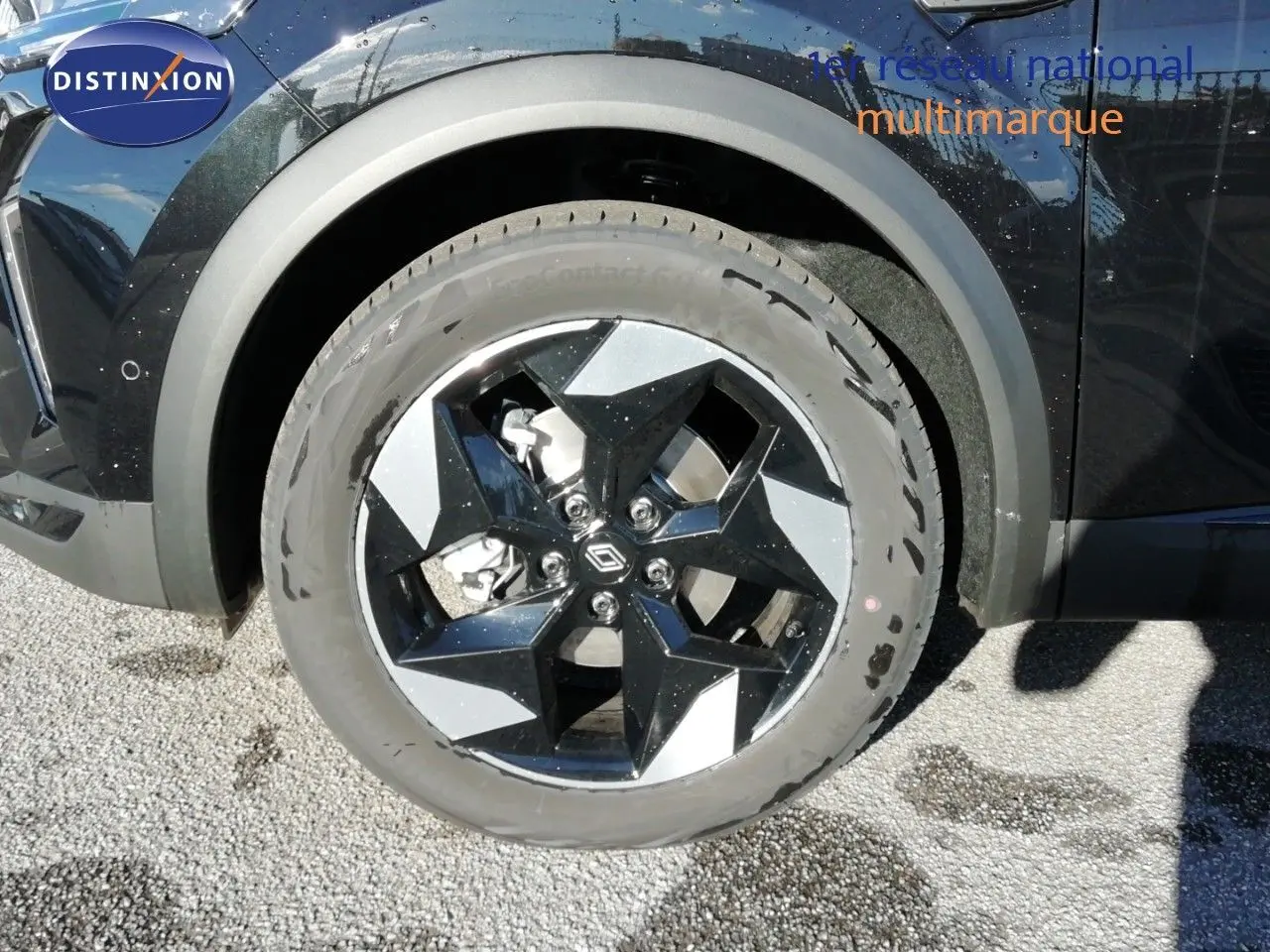 Gros plan sur la roue avant gauche du Renault Captur noir étoile métal, mettant en valeur la jante bi-ton distinctive.