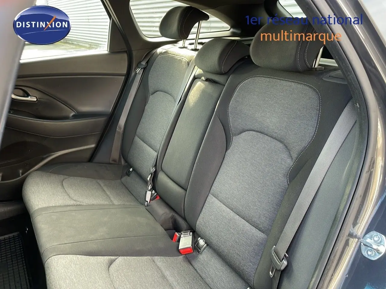Banquette arrière en tissu gris et noir de la Hyundai i30 SW 2024 vue côté droit avec ceinture de sécurité visible.