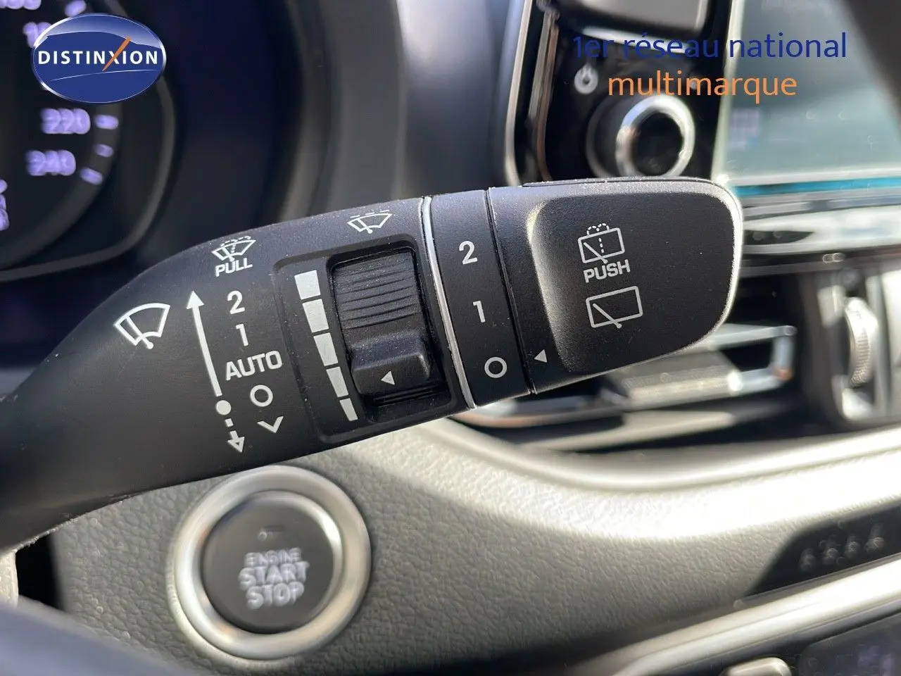 Gros plan sur la commande des essuie-glaces et le bouton start/stop dans l'habitacle d'une Hyundai i30 SW gris foncé.