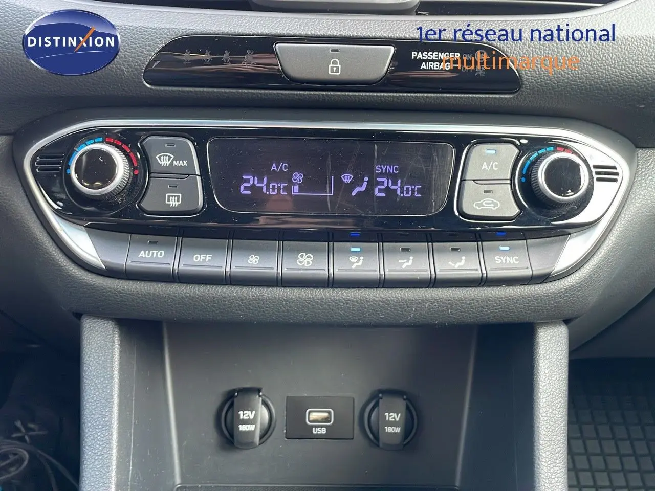 Vue rapprochée de la console centrale de la Hyundai i30 SW 2024, montrant la climatisation digitale et prises USB et 12V.