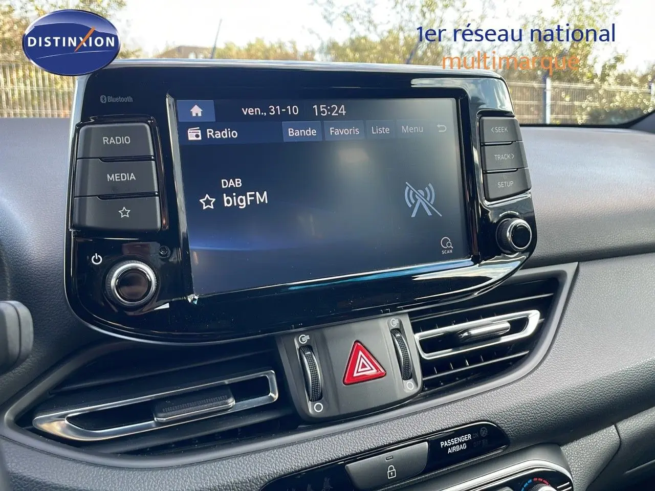 Tableau de bord de Hyundai i30 SW 2024 avec écran tactile radio et commandes centrales en vue rapprochée.
