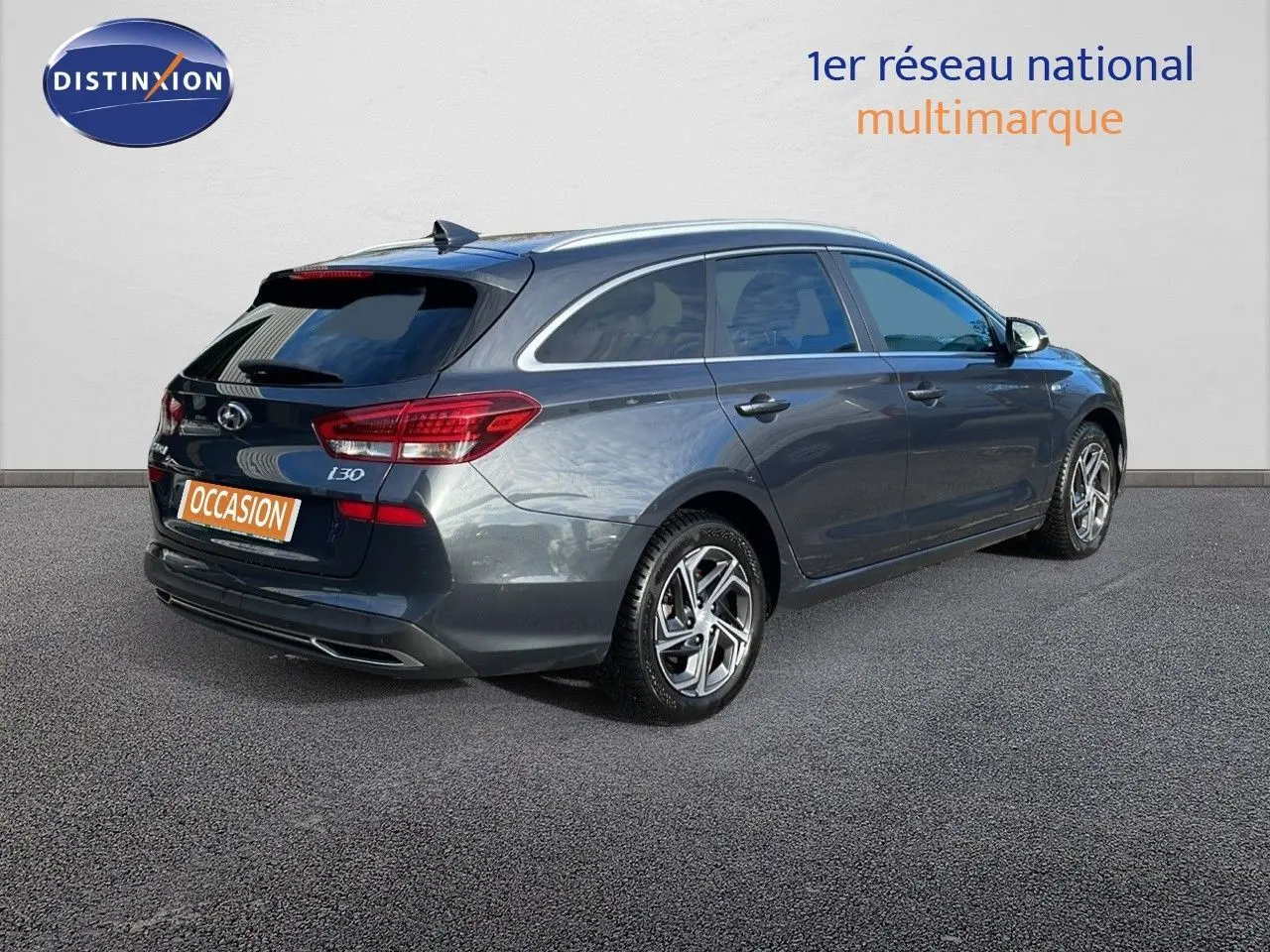 Vue 3/4 arrière droite d'une Hyundai i30 SW 2024 gris foncé Dark Knight Metal avec jantes alliage et feux LED.