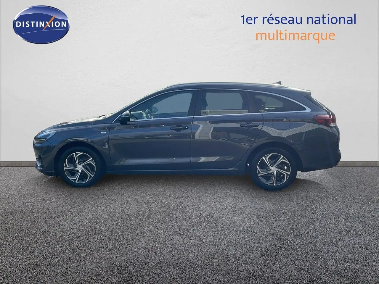 Profil latéral droit d'une Hyundai i30 SW 2024 en couleur Dark Knight Metal, avec jantes alliage et lignes élégantes.