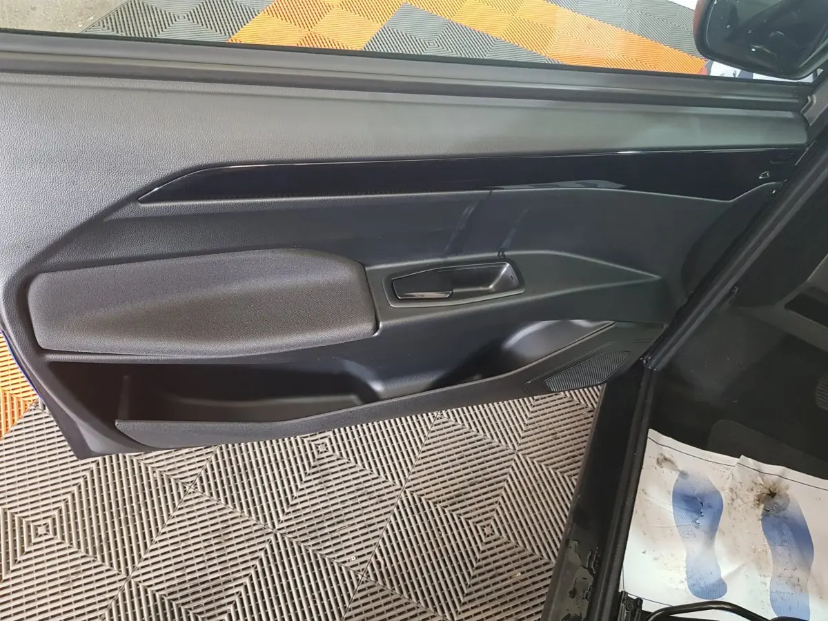 Vue intérieure de la porte côté conducteur d'une AIXAM Ambition 0.5 City Sport 2026 noire avec poignée intégrée.