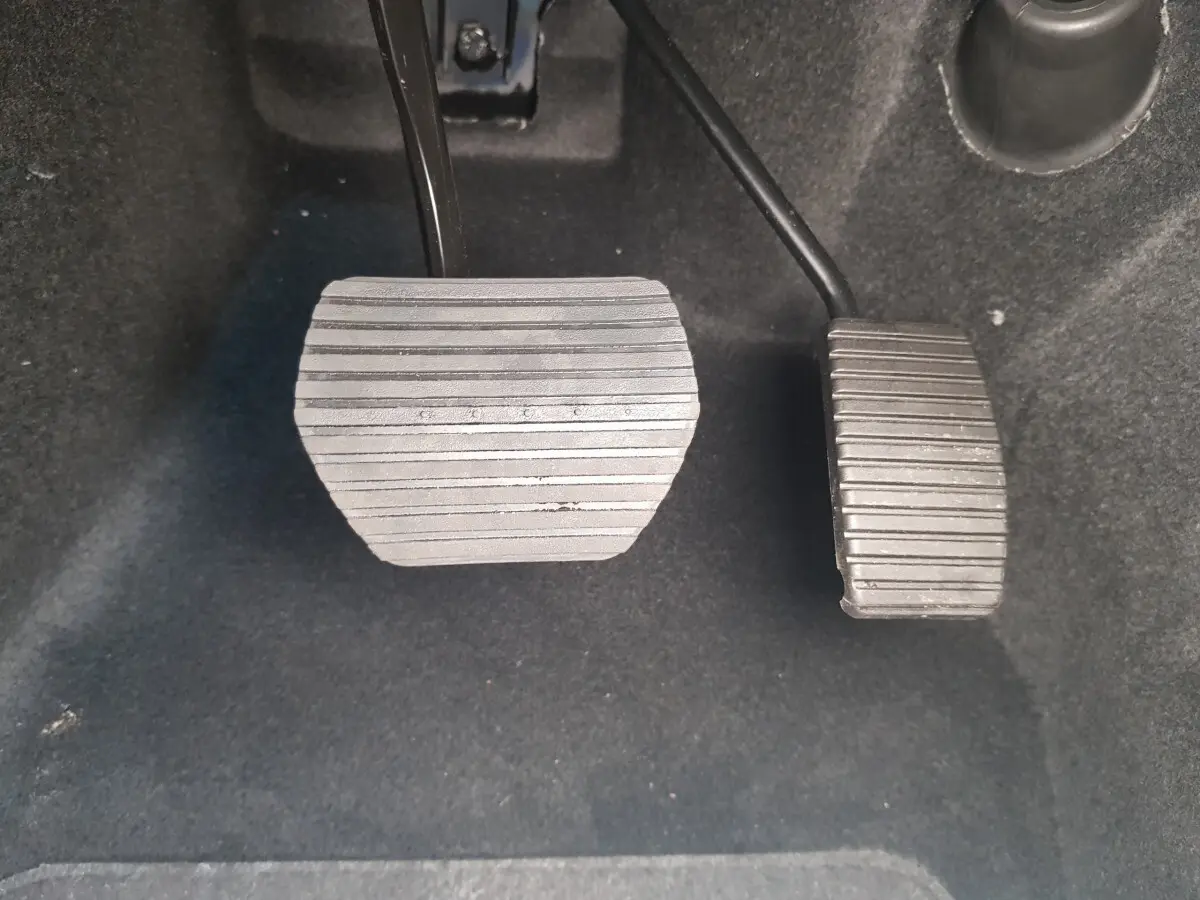 Gros plan sur les pédales d’accélérateur et de frein de l’AIXAM AMBITION 0.5 CITY SPORT 2026, intérieur noir.