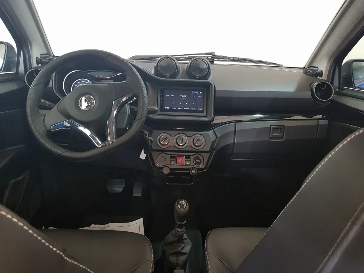 Vue intérieure frontale de l’AIXAM AMBITION 0.5 CITY SPORT 2026 avec tableau de bord noir et volant multifonction.