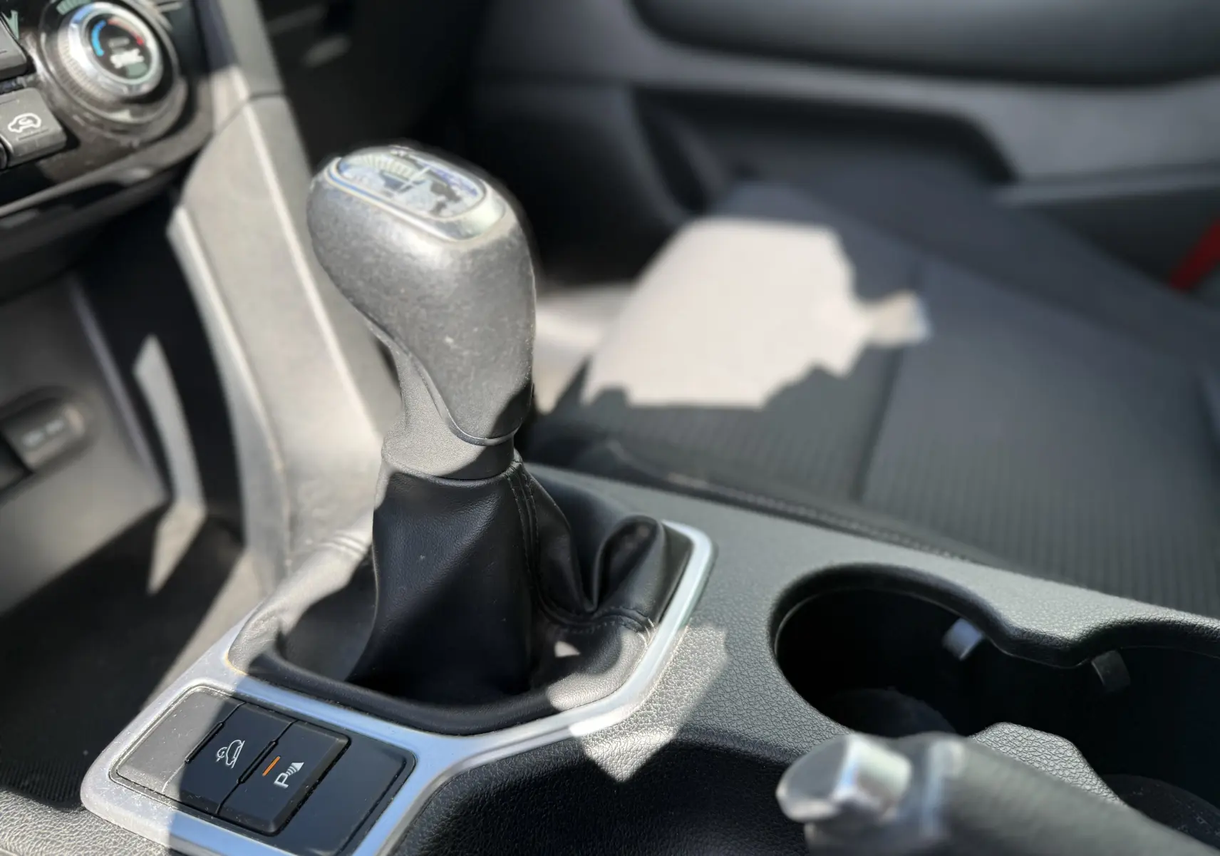 Gros plan sur le levier de vitesse manuel et la console centrale noire du Kia Sportage 1.6 CRDI 136 Blue Edition 2021.