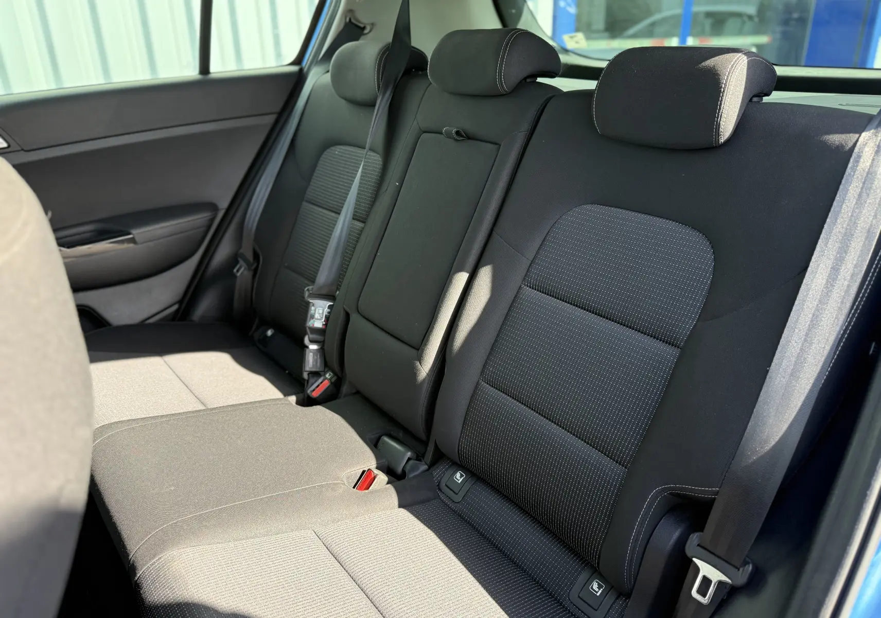 Vue intérieure côté droit des sièges arrière noirs du Kia Sportage 1.6 CRDI 136 Black Edition bleu de 2021.