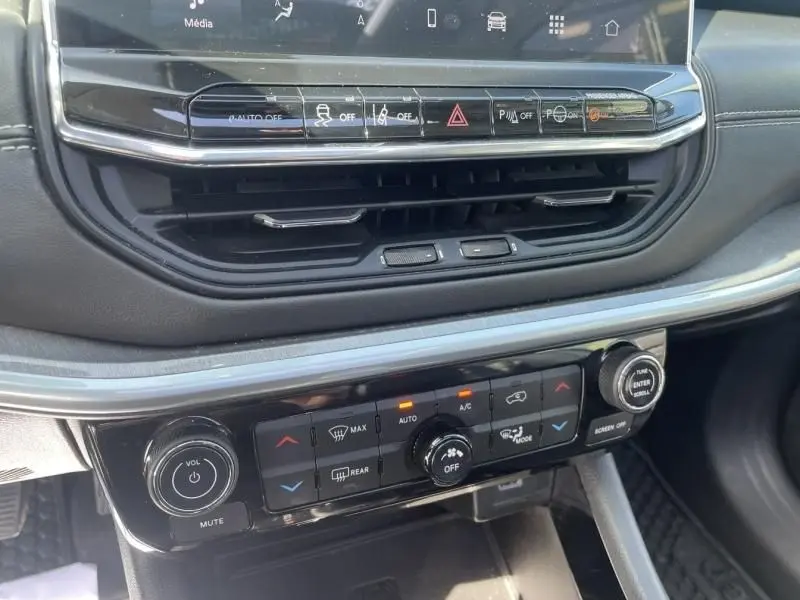 Détail de la console centrale du Jeep Compass 2023 gris métal, montrant les commandes climatisation et audio.