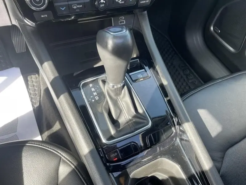 Gros plan sur la console centrale du Jeep Compass 2023, montrant le levier de vitesse automatique en cuir noir.
