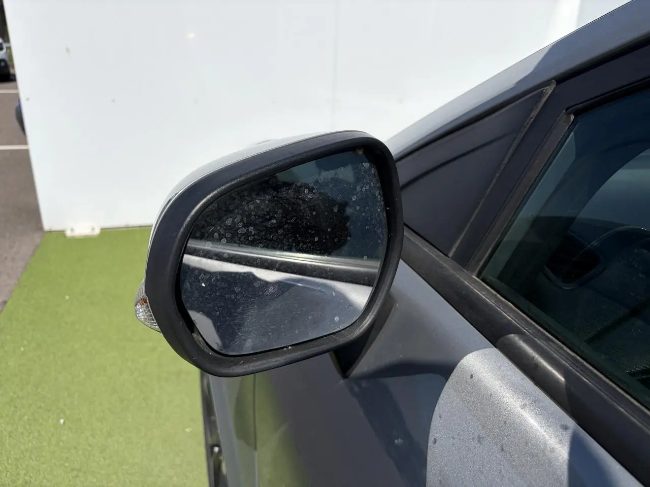 Rétroviseur côté gauche d’un Ford Puma gris métal, avec clignotant intégré et carrosserie visible en arrière-plan.