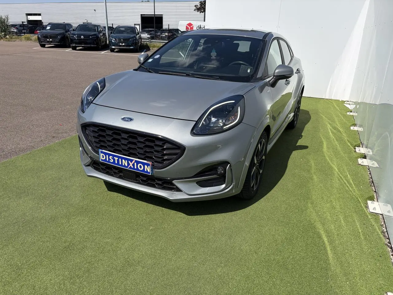 Ford Puma gris métal vue 3/4 avant droit avec calandre noire et jantes alliage noires.